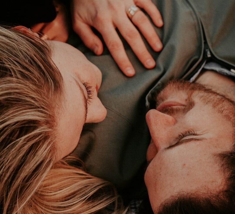 a woman stares into a man's eyes lovingly